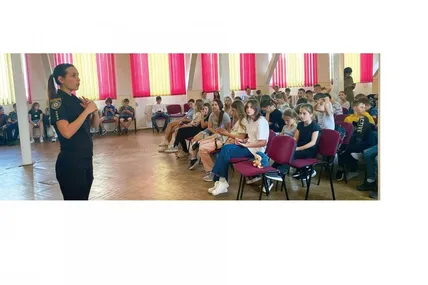 Кіберполіцейська проводить лекцію для дітей.