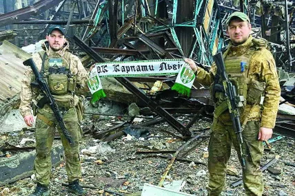 Арсен Дмитрик (справа) із побратимом у знищеному ворогом Маріуполі. Про мирне життя їм нагадує шалик футбольного клубу “Карпати”. Фото з особистого архіву Арсена Дмитрика