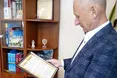 Суддя Плотніцький тримає в кабінеті три томи творів митрополита Шептицького: це презент від Садового