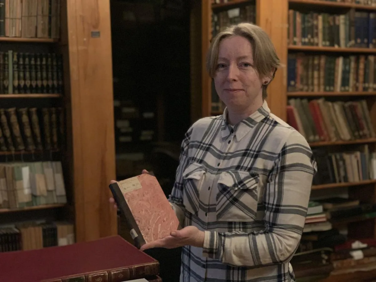 Реставраторка Уляна Романів показує відновлену книгу
